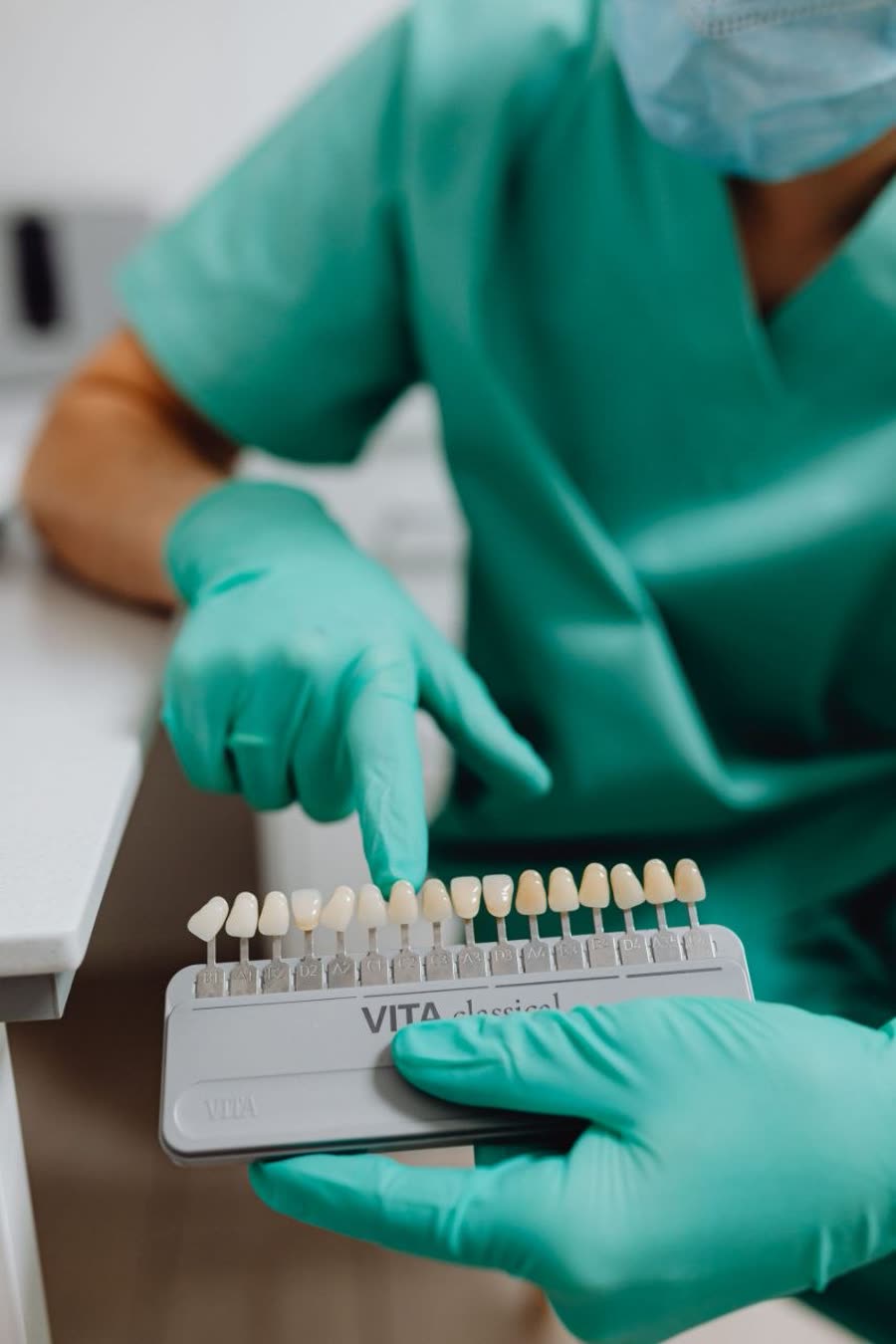 Manos sosteniendo una guía de color dental VITA